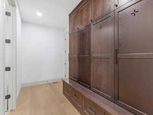 Mudroom with light wood finished floors and recessed lighting