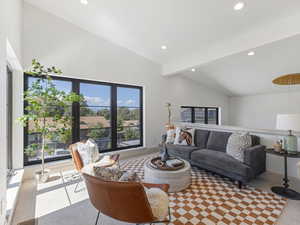 Living area featuring beamed ceiling, recessed lighting, and high vaulted ceiling