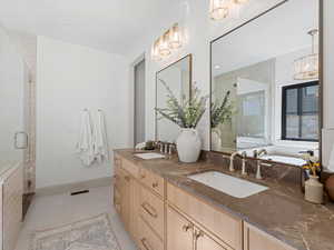 Bathroom with a shower stall, double vanity, and a chandelier