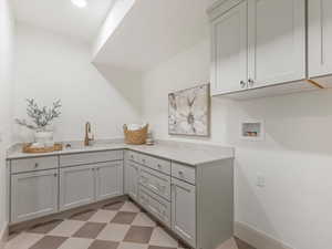 Laundry room featuring washer hookup, cabinet space, and light floors