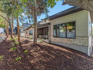 Back of property featuring a patio area and stone siding