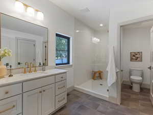 Full bathroom featuring vanity, walk in shower, recessed lighting, and dark tile patterned floors