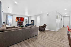 Living room featuring light wood-style flooring, plenty of natural light, and recessed lighting