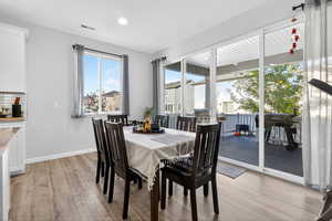 Dining room with light wood-type flooring and recessed lighting