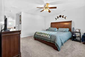 Bedroom with light colored carpet and ceiling fan