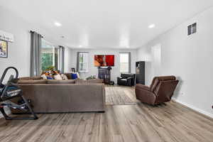 Living room featuring light wood-style flooring and recessed lighting