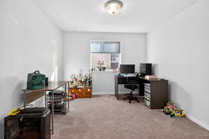 Home office featuring light colored carpet and baseboards