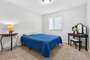 Bedroom with light colored carpet and baseboards