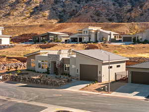 Contemporary house with stone siding, driveway, a mountain view, stucco siding, and a garage