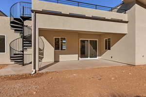 Rear view of property with stairs, stucco siding, and a patio