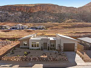 Contemporary home with stone siding, a mountain view, driveway, stucco siding, and a garage
