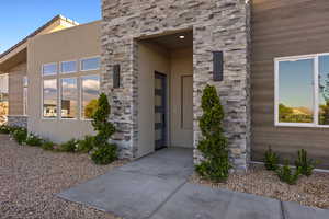 View of exterior entry with stone siding and stucco siding