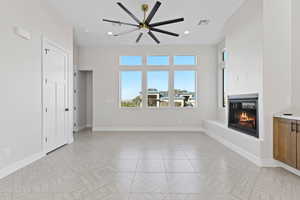 Unfurnished living room featuring a glass covered fireplace, recessed lighting, and ceiling fan