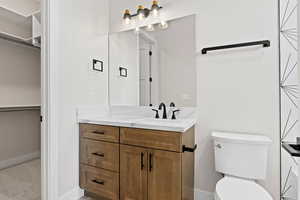 Full bath featuring vanity and a walk in closet