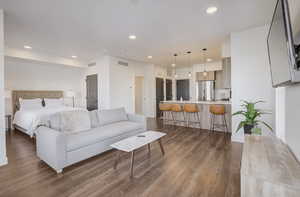 Bedroom featuring recessed lighting, dark wood finished floors, and freestanding refrigerator