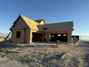 Property under construction featuring a shingled roof, a mountain view, and a patio area
