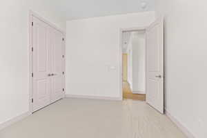 Unfurnished bedroom featuring light carpet and a closet