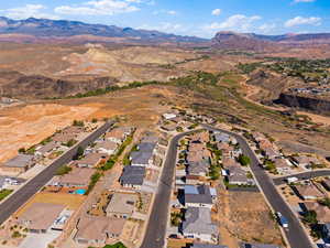 Aerial view of property and surrounding area with a mountain backdrop and nearby suburban area
