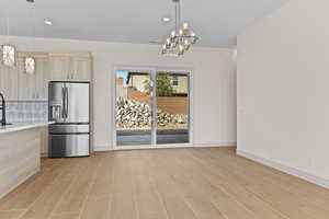 Unfurnished dining area featuring recessed lighting, a chandelier, and light wood-type flooring