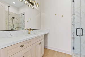 Bathroom with a marble finish shower and vanity