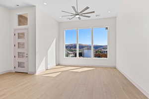 Spare room with a mountain view, recessed lighting, ceiling fan, and light wood-style floors