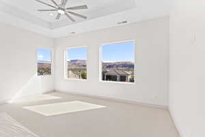 Carpeted spare room with a raised ceiling, a ceiling fan, a mountain view, and recessed lighting
