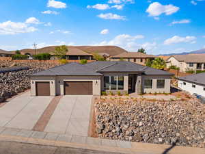 Prairie-style house with a garage, a residential view, stucco siding, and concrete driveway