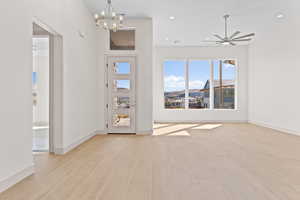 Foyer with ceiling fan, light wood-style floors, a chandelier, and recessed lighting