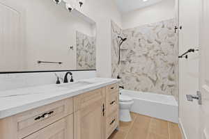 Full bathroom with washtub / shower combination, vanity, and light wood-style floors
