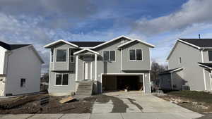 Bi-level home featuring an attached garage and concrete driveway