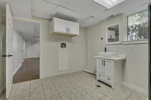 Washroom with light tile patterned floors, a paneled ceiling, and washer hookup