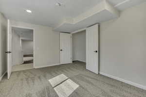 Unfurnished bedroom with baseboards and light colored carpet