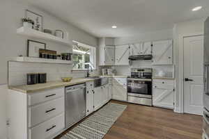 Kitchen featuring open shelves, white cabinetry, appliances with stainless steel finishes, and recessed lighting