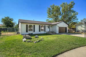 Ranch-style house featuring brick siding, concrete driveway, a garage, and a gate