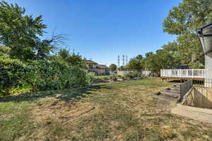 View of yard featuring a wooden deck and a garden