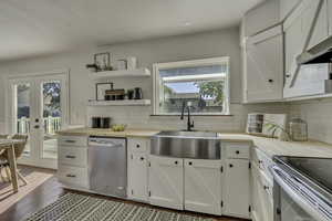 Kitchen with butcher block countertops, white cabinets, appliances with stainless steel finishes, and dark wood finished floors