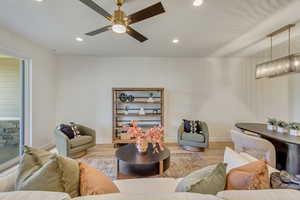 Living room with wood finished floors, recessed lighting, and ceiling fan