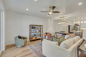 Living room featuring recessed lighting, light wood-style floors, and a ceiling fan