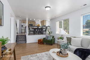 Living room with light wood-type flooring and stairs