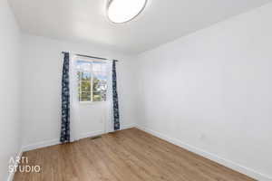 Unfurnished room with light wood finished floors and baseboards