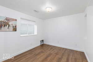 Spare room with dark wood finished floors and a textured ceiling