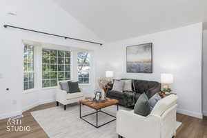 Living area featuring dark wood finished floors and high vaulted ceiling
