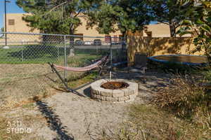 View of yard featuring a fire pit and a trampoline