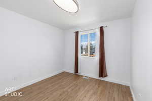 Unfurnished room featuring light wood-style floors and baseboards