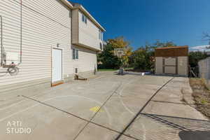 View of basketball court with a shed, a patio area, and community basketball court