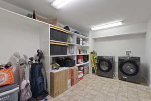 Washroom featuring a textured wall, a textured ceiling, and washing machine and clothes dryer