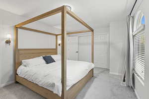 Bedroom with light carpet and a closet