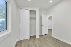 Unfurnished bedroom featuring light wood finished floors, recessed lighting, and a closet