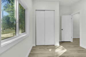 Unfurnished bedroom featuring a closet, light wood finished floors, and elevator