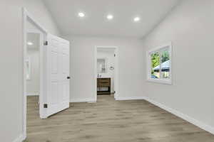 Unfurnished bedroom featuring light wood-style floors, recessed lighting, and connected bathroom